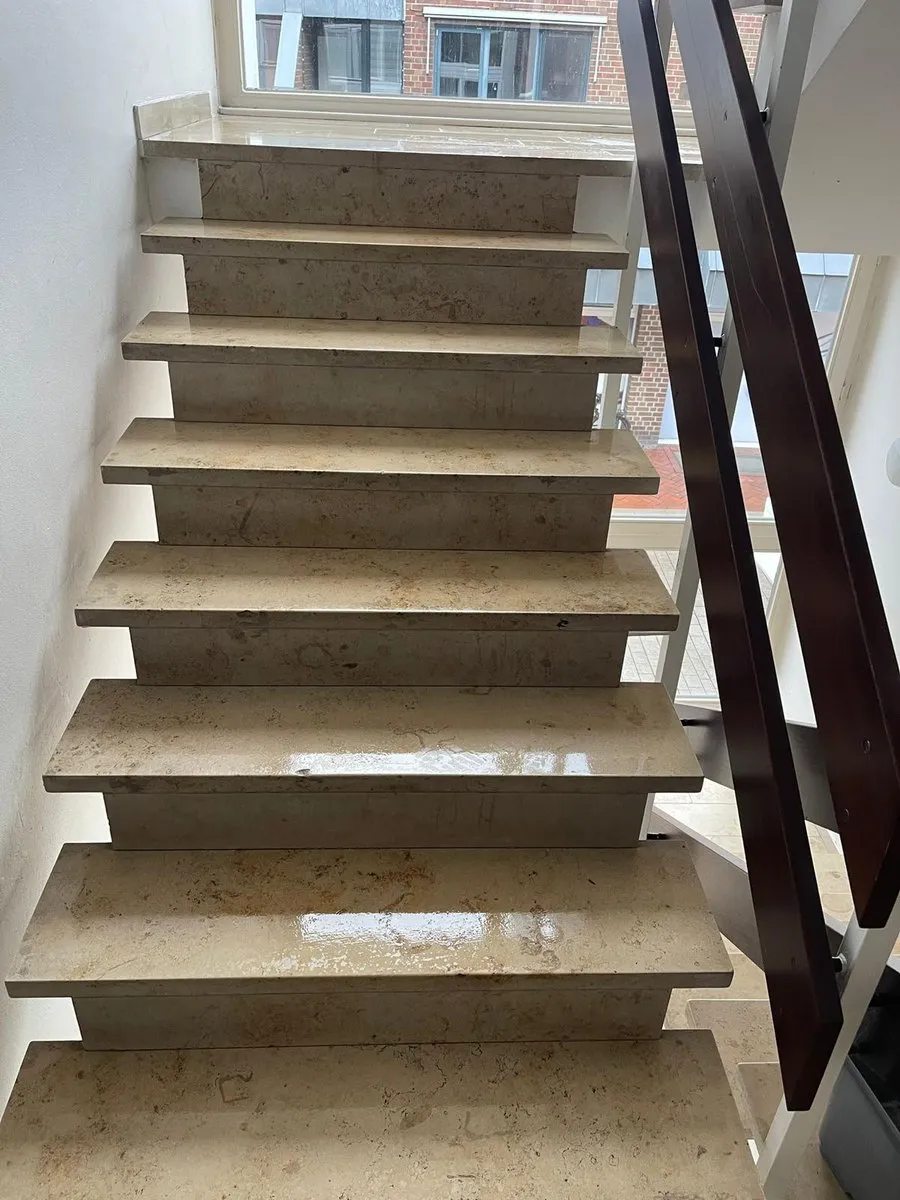 Helle Steintreppe mit Holzhandlauf nach der Reinigung